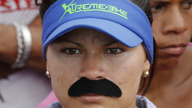 A woman dons a fake moustache emulating that of Venezuela's Nicolas Maduro, at a pro-government rally in Caracas on  Saturday.