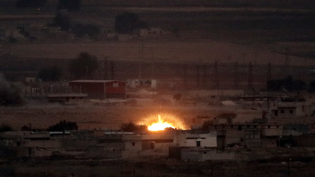 Fire is seen in the Syrian town of Ras al-Ain as seen from Ceylanpinar, Turkey. 