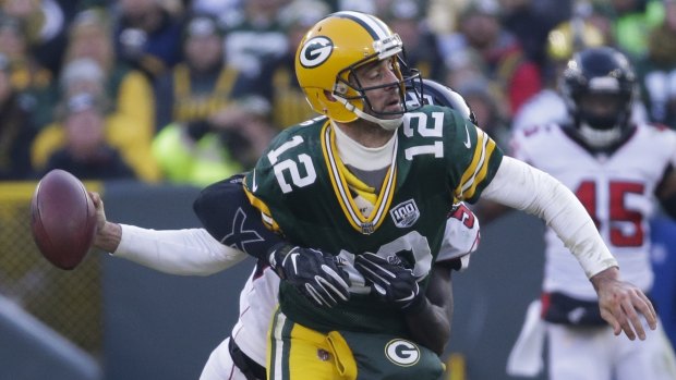 Green Bay's Aaron Rodgers throws the ball as he is hit by the Falcons' De'Vondre Campbell.