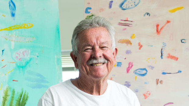Ken Done in his Sydney studio with recent paintings Dive 4, 2019 (left), and Big December Beach, 2018. 