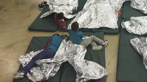 People who've been taken into custody rest in one of the cages at a facility in McAllen, Texas.