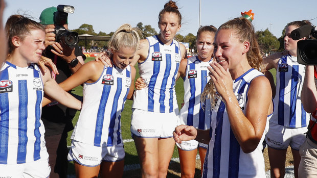 Tuning up: Beth Lynch of the Kangaroos (centre) and teammates sing the team song after the Round 4 win over the Demons.