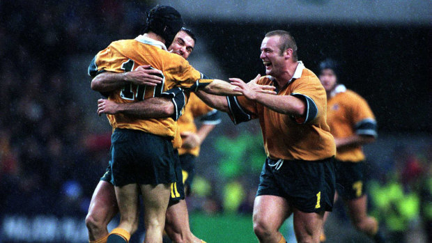 Joe Roff and Richard Harry swamp Stephen Larkham after his field goal in extra time won Australia's semi-final against South Africa in the 1999 World Cup.