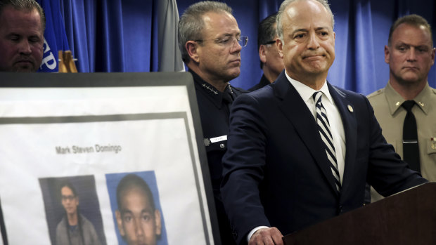 US attorney Nick Hanna stands next to photos of Mark Domingo during a news conference in Los Angeles. 