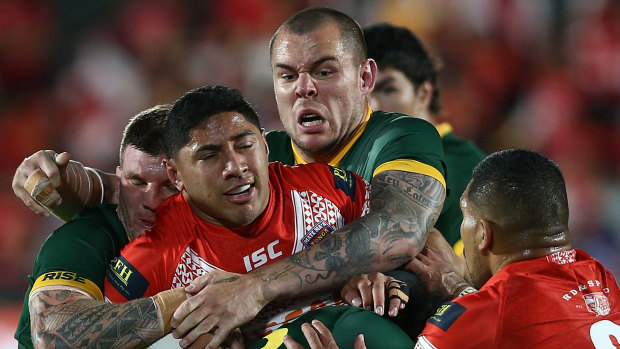 Surrounded: David Klemmer wraps up Jason Taumalolo in the Tonga Test in Auckland.