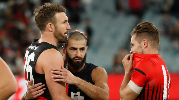 Adam Saad is congratulated by former Bombers team mates Cale Hooker and David Zaharakis. 