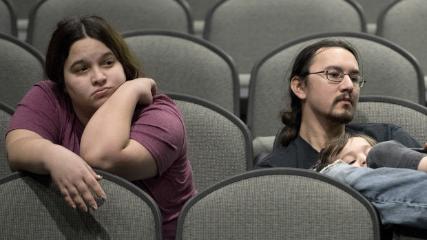 Jeff Lopez, his son Tristan and wife Jessika wait in an area for Bernie Sanders supporters during the Woodbury County Third Precinct Democratic caucus in Sioux City, Iowa.