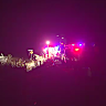 One person is dead and at least two others are fighting for life after a bus rollover in north Queensland injured about 20 people.