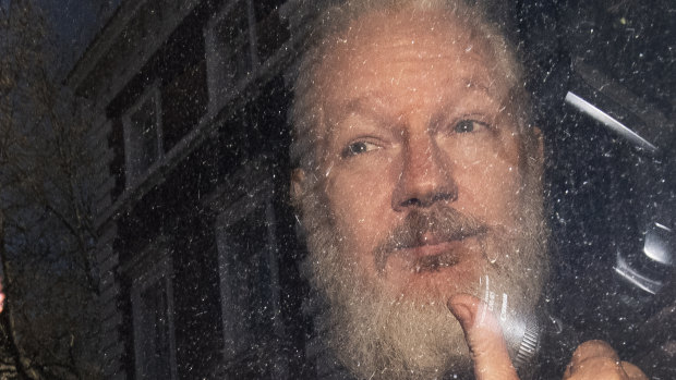 Julian Assange gestures as he arrives at Westminster Magistrates' Court.