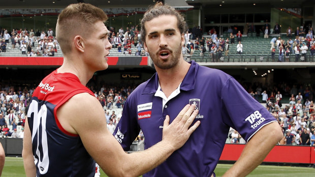 Adam Tomlinson consoles Alex Pearce after the Docker was injured in round one against Melbourne. 