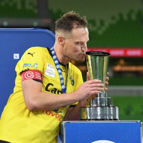 Sealed with a kiss: Heidelberg United captain Luke Byles with the NPL Champioship trophy. 