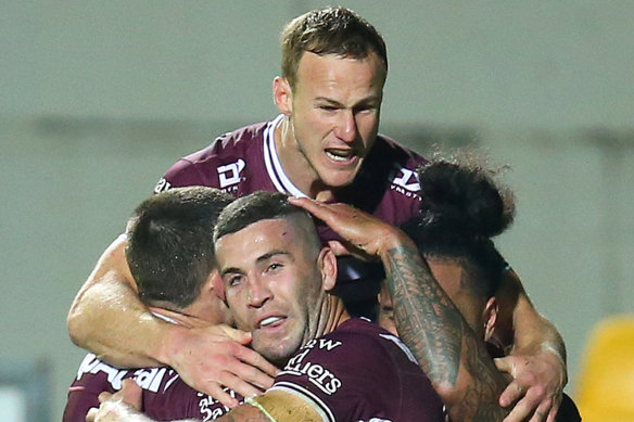 Joel Thompson of the Sea Eagles is congratulated by teammates after scoring a try.