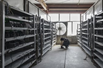 A technician inspects bitcoin mining machines at a mining facility in inner Mongolia.