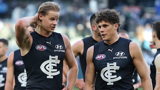 Disapointed Carlton players Tom De Koning and Charlie Curnow walk from the ground.