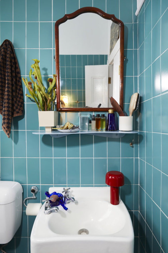 “Thankfully the bathroom was already renovated, and I adore the tiles,” says Mooney. The vase is designed by Hattie Molloy and the shelf is by Nicole Lawrence Design.