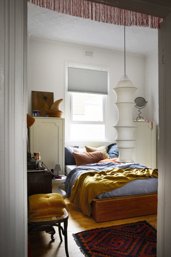 Ben’s bedroom is filled with a lifetime of collected art and objects, and French linen bedding in warm tones. The ceiling light is by Bruno Munari.