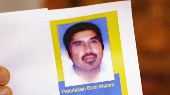 An Indonesian Police Officer shows an undated photo of suspected al-Qaeda operative Hambali during a news conference in 2003.