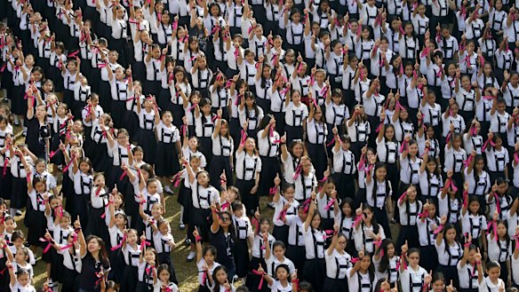 Thousands of students and faculty from St. Scholastica's College, Manila, flash No. 1 signs at the end of a mass dance, dubbed "One Billion Rising", on the 7th anniversary of the global movement to help eradicate violence against women and children.