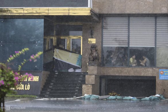 People sit inside a building in Nghe An province, Vietnam as Typhoon Kajiki was approaching.