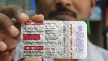 A pharmacist holds a pack of hydroxychloroquine tablets.