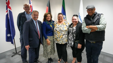 Ruska family members representing the Yuggerah First Nations people pose with Brisbane Games president Andrew Liveris (second from left) at City Hall.