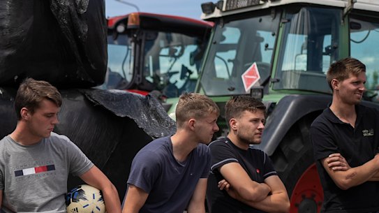 Protesting farmers talk at a blockade outside a distribution centre for supermarket chain Aldi in the town of Drachten, northern Netherlands, on July 4.
