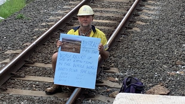 Rick Pass, 54, protests against climate change while chained to railway lines at Bowen Hills on Wednesday morning.