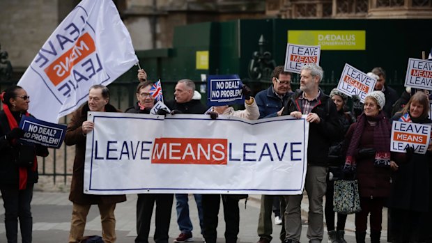 Leave the European Union supporters hold placards and protest across the street from the Houses of Parliament.