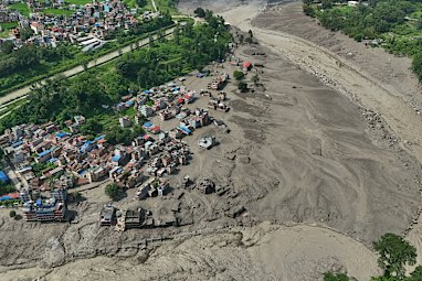 Damaged houses stand precariously near the swollen, debris-choked banks of the Trishuli River after flash floods in Nepal’s Nuwakot district.