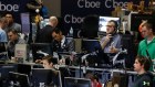 Traders work in a trading pit at the Chicago Board Options Exchange, Monday, Dec. 11, 2017, in Chicago, as they trade futures and options unrelated to bitcoin. Trading in bitcoin futures began Sunday on the CBOE. (AP Photo/Kiichiro Sato)