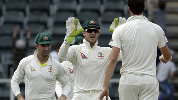 Australia's captain Tim Paine, centre, celebrates with bowler Pat Cummins after dismissing South Africa's Quinton de Kock.