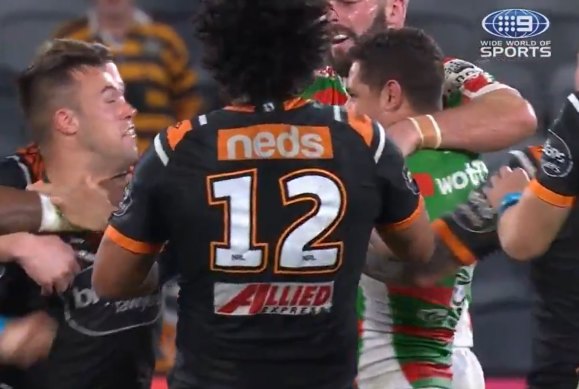 Wests Tigers half Luke Brooks trades blows with South Sydney's Dane Gagai.