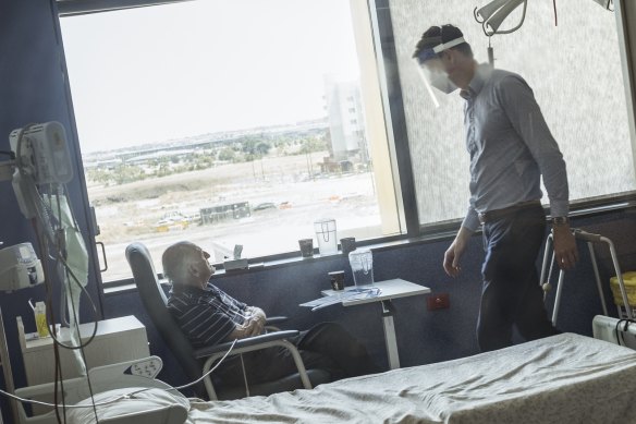 Associate Professor Craig Aboltins checks on COVID patient Raymond Daly, 86, at the Northern Hospital in Epping.