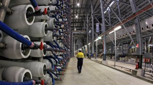 An employee of the Sydney Desalination plant walks past some of its 36,000 polymer membranes used to filter salt and other impurities from seawater so that it is suitable for drinking.