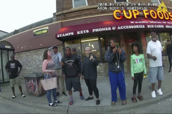 This May 25, 2020, file image from a police body camera shows  Darnella Frazier, third from right, filming police officer Derek Chauvin kneeling on the neck of George Floyd. 