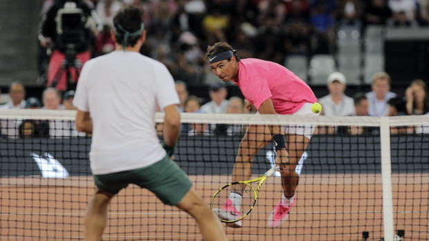 Rafael Nadal advances to the net against Federer.