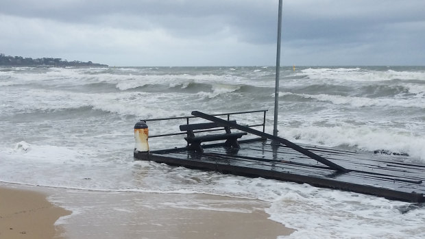 A part of Frankston Pier floats on the shoreline after breaking off during wild weather on Friday.