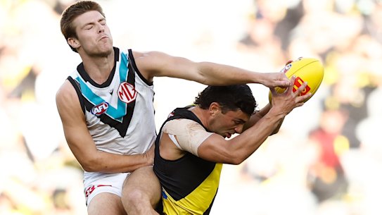 Tim Taranto of the Tigers and Dylan Williams of the Power collide at the MCG on Sunday.