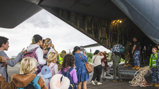 Australian and other tourists board an Australian Airforce Hercules as they prepare to depart from Magenta Airport in Noumea, New Caledonia on Tuesday.