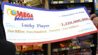 Ishar Gill, left, his father Jaspal Singh, centre and his sister Jaspeet Gill right, look over the enlarged image of a cheque that will be presented to the winner of the $US1.22 billion Mega Millions Lotto ticket that was purchased at their family’s store in Cottonwood, California.