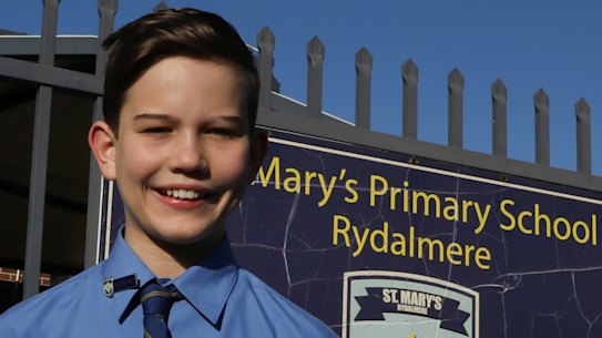 Smiles and balloons: Sandy Keyser is greeted by his principal Richard Blissenden at the school gates on Friday.