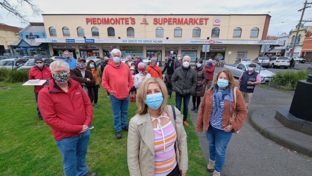 Glen McCallum, Elda Colagrande and Polly Helsing with other residents outside Piedimonte's Supermarket in North Fitzroy on Thursday.