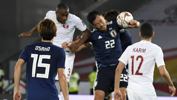 Japan's defender Maya Yoshida (second from right), plays a hand ball in the penalty box.