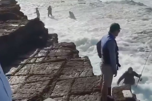 Os pescadores fogem quando são inundados por uma onda enquanto pescam nas rochas perto de Port Kembla. 