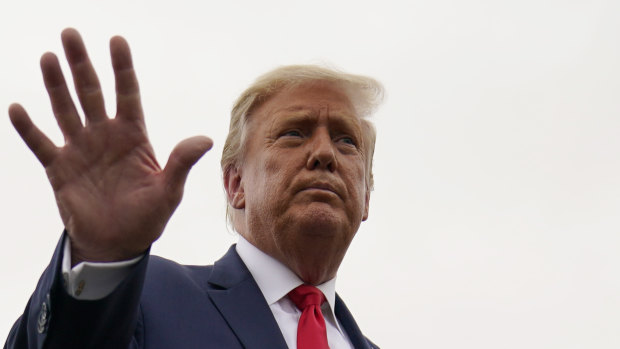 US President Donald Trump walks away from the media to board Air Force One for a trip to a campaign rally in Michigan.