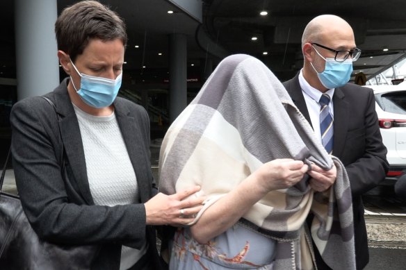 Homicide detectives escort the woman from Sydney Airport after extraditing her for the 1987 murder of her daughter. 