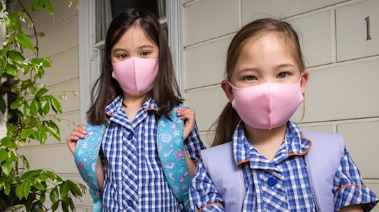 Grace and Sarah wear masks to school in 2021.