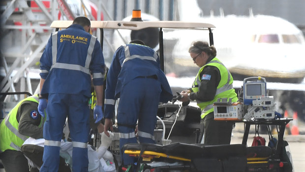 A survivor is removed from a RAAF Hercules at Sydney Airport on Thursday.