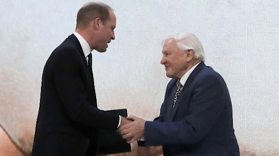 Britain's Prince William, left, and Sir David Attenborough, broadcaster and natural historian, shake hands after participating in a session at the annual meeting of the World Economic Forum in Davos, Switzerland, 