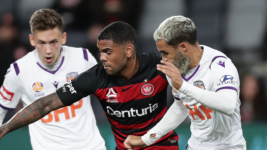 Western Sydney Wanderers forward Kwame Yeboah squeezes through two Perth Glory opponents.